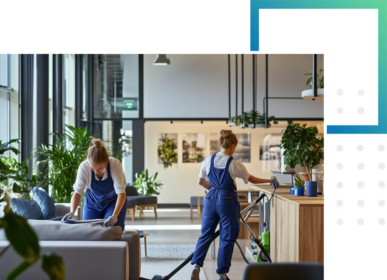 Zwei Reinigungskräfte säubern sorgfältig ein helles, modern eingerichtetes Büro mit Pflanzen.