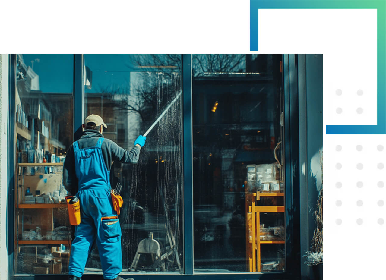 Mann reinigt große Schaufensterscheibe mit Teleskopstange.